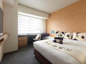 a hotel room with a bed with a teddy bear on it at Mitsui Garden Hotel Ueno - Tokyo Reopened in July 2023 in Tokyo