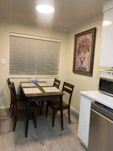 eine Küche mit einem Tisch und Stühlen im Zimmer in der Unterkunft 舒服民宿 in Vancouver