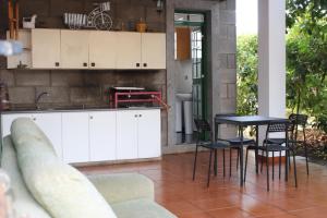 cocina con armarios blancos, mesa y sillas en Casita Lily en Las Palmas de Gran Canaria