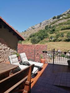 un patio con 2 sillas y una mesa en APARTAMENTOS RURALES EL PRIVILEGIO, en La Plaza