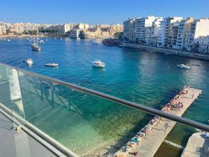 a view of a river with boats in the water at Seafront Two Bedroom Apartment in St. Julianʼs