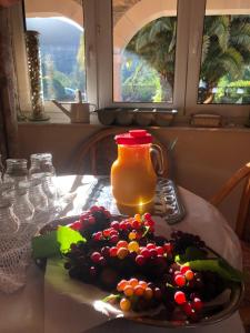 a plate of fruit on a table with a pitcher of juice at Posada El Urogallo en el Valle de Cabuérniga in Renedo