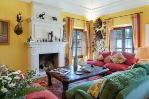 a living room with a red couch and a fireplace at Hacienda el Burgo in Mairena del Aljarafe