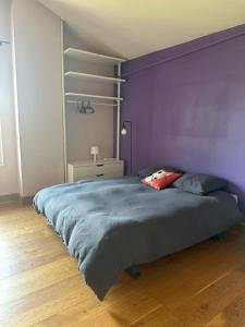 a bedroom with a large bed with a purple wall at Relais DAIA 
