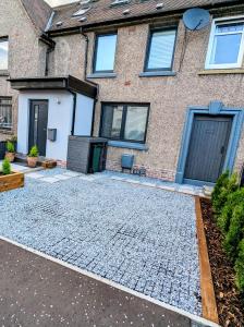 a house with a cobblestone driveway in front of it at Cosy guest room in a family home in Edinburgh