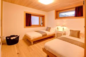 a hotel room with two beds and a window at Chalet Chloe - Saas-Fee in Saas-Fee