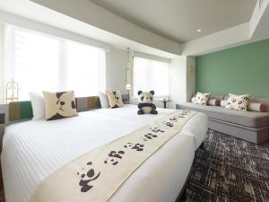 een slaapkamer met 2 bedden, pandabeeren en een bank bij Mitsui Garden Hotel Ueno - Tokyo Reopened in July 2023 in Tokyo
