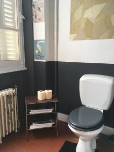 a bathroom with a toilet and a table with towels at La Ptite Fabrique chez Malot in Montceau-les-Mines +19 photos