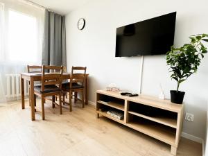 a dining room with a table and a tv on a wall at Home and Sea in Gdańsk