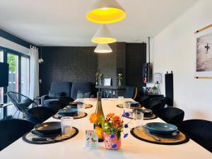 a table with black chairs and a yellow light at Villa - Stilvolles Boutique Landhaus in Grömitz +40 photos