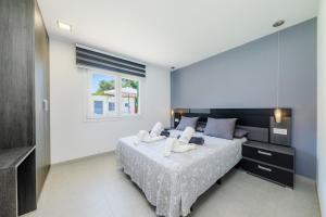 a bedroom with a bed with white sheets and a window at Villa Neptuno in Cala Ratjada +22 photos