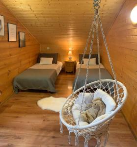 una habitación con 2 camas y un columpio con un osito de peluche en Oreeduloup Chalet Grand Loup 14/16 pers., en Le Dévoluy