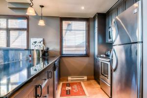 a kitchen with a stainless steel refrigerator at Luxurious Altitude Ski-in/Ski-out in Mont-Tremblant