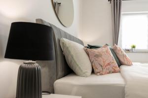 sala de estar con sofá con almohadas y lámpara en apartmani SUN & MOON, en Bjelovar