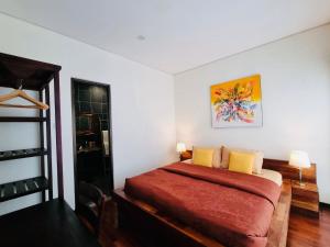 Un dormitorio con una cama con una manta roja y almohadas amarillas. en Bali 3BR Family Nicho House, en Seminyak