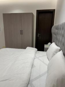 a bed with white sheets and pillows in a bedroom at اطلالة الريان شقة خاصة in Jeddah