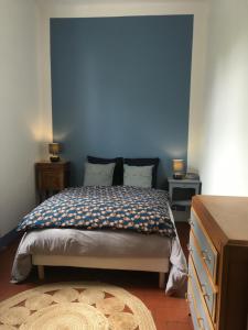 um quarto com uma cama com uma parede azul em La P’tite Fabrique em Montceau-les-Mines