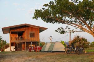 a house with a tent and bikes parked in front of it at Ha Me Garden ฮามีการ์เด้น โฮมสเตย์ฝาง in Fang