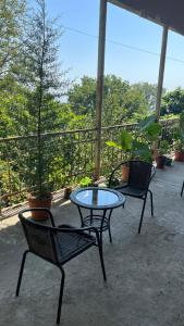 eine Terrasse mit 2 Stühlen und einem Tisch auf der Terrasse in der Unterkunft House In The Forest in Sighnaghi