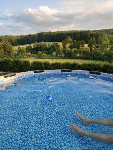 - une piscine d'eau bleue avec deux pieds dans l'établissement Domek w Grabówce, 