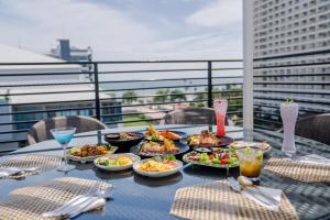 une table avec des assiettes de nourriture sur un balcon dans l'établissement HT9 Hotel, à Jomtien Beach