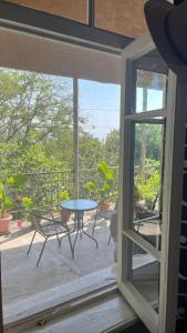 ein Fenster mit Blick auf eine Terrasse mit einem Tisch und Stühlen in der Unterkunft House In The Forest in Sighnaghi