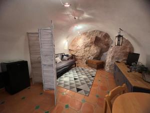Studio en voûte في بودوان: غرفة مع أريكة أمام جدار صخري