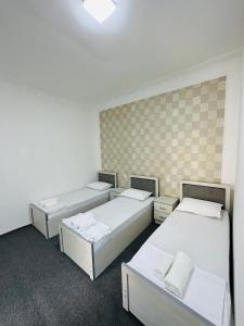 Cette chambre comprend 3 lits. dans l'établissement AL-MOTRUDIY, à Samarcande