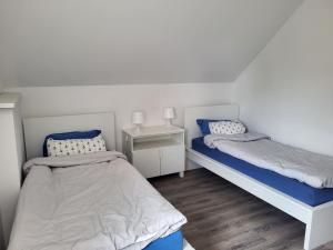 a bedroom with two beds with blue and white sheets at Nr.11 Apartamenty 