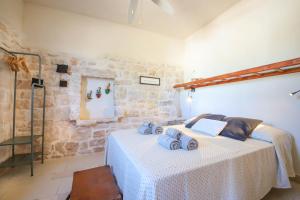 a bedroom with a bed with towels on it at TD Trulli Albapetra Pool Olive Trees in Polignano a Mare +29 photos