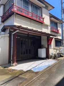 a house with a large door with a balcony at 素泊まり民宿とみや in Oshima