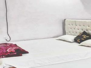 a white bed with two pillows on top of it at OYO Flagship 83165 Hotel Om Shanti in Khagaul