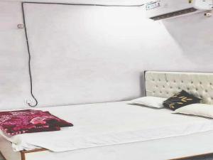a white bed with a headboard and pillows on it at OYO Flagship 83165 Hotel Om Shanti in Khagaul