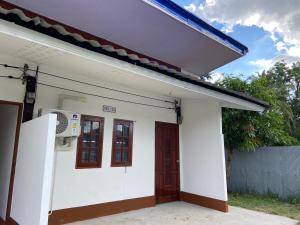 a white house with a door and a window at ศรีวดีโฮม(Sriwadee Home) in Ban Phai