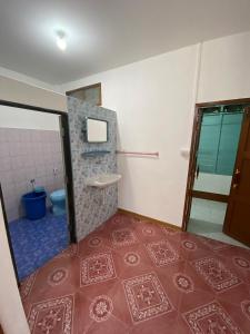 a bathroom with a toilet and a tile floor at ศรีวดีโฮม(Sriwadee Home) in Ban Phai