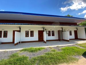 a large white building with doors and windows at ศรีวดีโฮม(Sriwadee Home) in Ban Phai