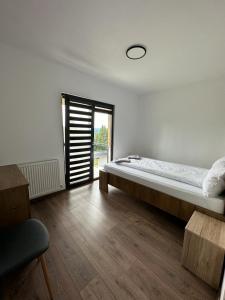 a bedroom with a large bed and a window at Cabana The One in Beliş
