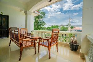 porche con 2 sillas, mesa y balcón en Ravoeun Angkor Boutique en Siem Reap
