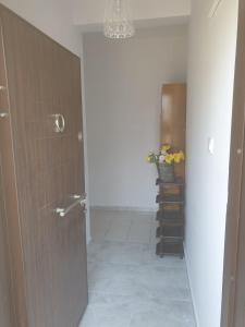 a hallway with a bathroom with a door and a vase of flowers at Beldibi Apart Homes in Antalya