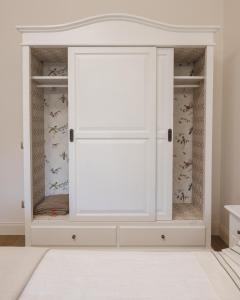a white wardrobe with doors in a room at Villa Platani Luxury Suite in Cianciana
