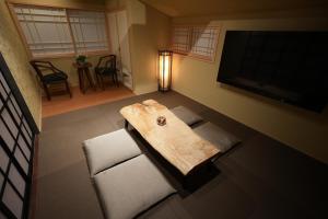 富士吉田的住宿－お宿 櫻川　Oyado Sakuragawa，一间配备有桌子和两把椅子及一台电视的房间