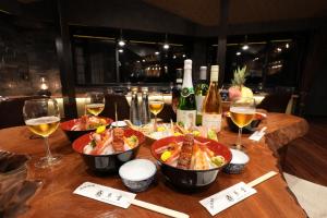 富士吉田的住宿－お宿 櫻川　Oyado Sakuragawa，一张桌子,上面放着两碗食物和酒杯