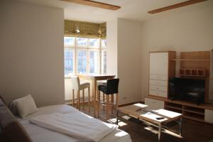 a bedroom with a bed and a table and a television at Hotel Goldene Krone Innsbruck in Innsbruck