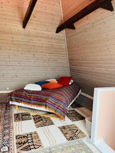Villa i hyggelige omgivelser في رودكوبينغ: سرير في غرفة بجدار خشبي