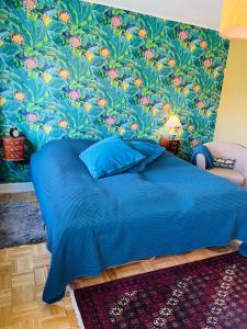 Villa i hyggelige omgivelser في رودكوبينغ: غرفة نوم بسرير ازرق وورق جدران