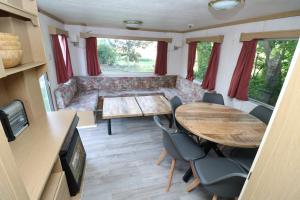 a living room with a table and a couch at De Zuidvliet chalet 1 in Wolphaartsdijk