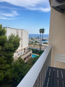 a balcony with a view of a building and the ocean at Studio La Cigale bord de mer in Menton