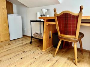 uma cozinha com uma mesa, uma cadeira e um frigorífico em Hotel Garni Römerhof em Innsbruck