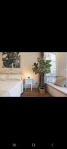 a bedroom with a bed and a plant next to a window at Villa Platani Luxury Suite in Cianciana