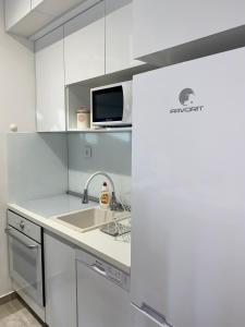 een witte keuken met een wastafel en een magnetron bij Apartment Gala S in Kotor